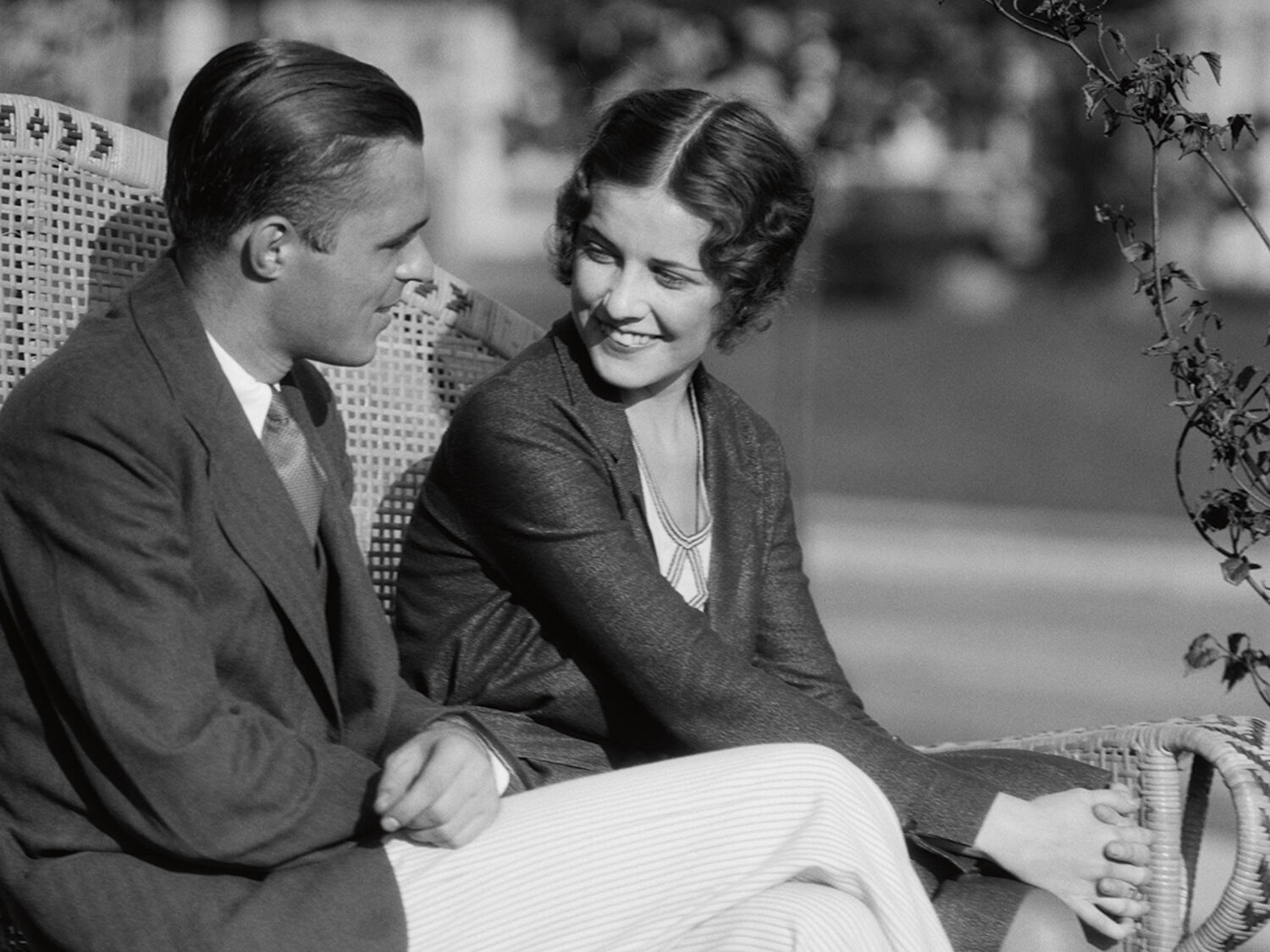 1930s SMILING COUPLE SITTING TOGETHER ON WICKER BENCH HUSBAND WIFE OUTDOOR  (Photo by H. Armstrong Roberts/ClassicStock/Getty Images)